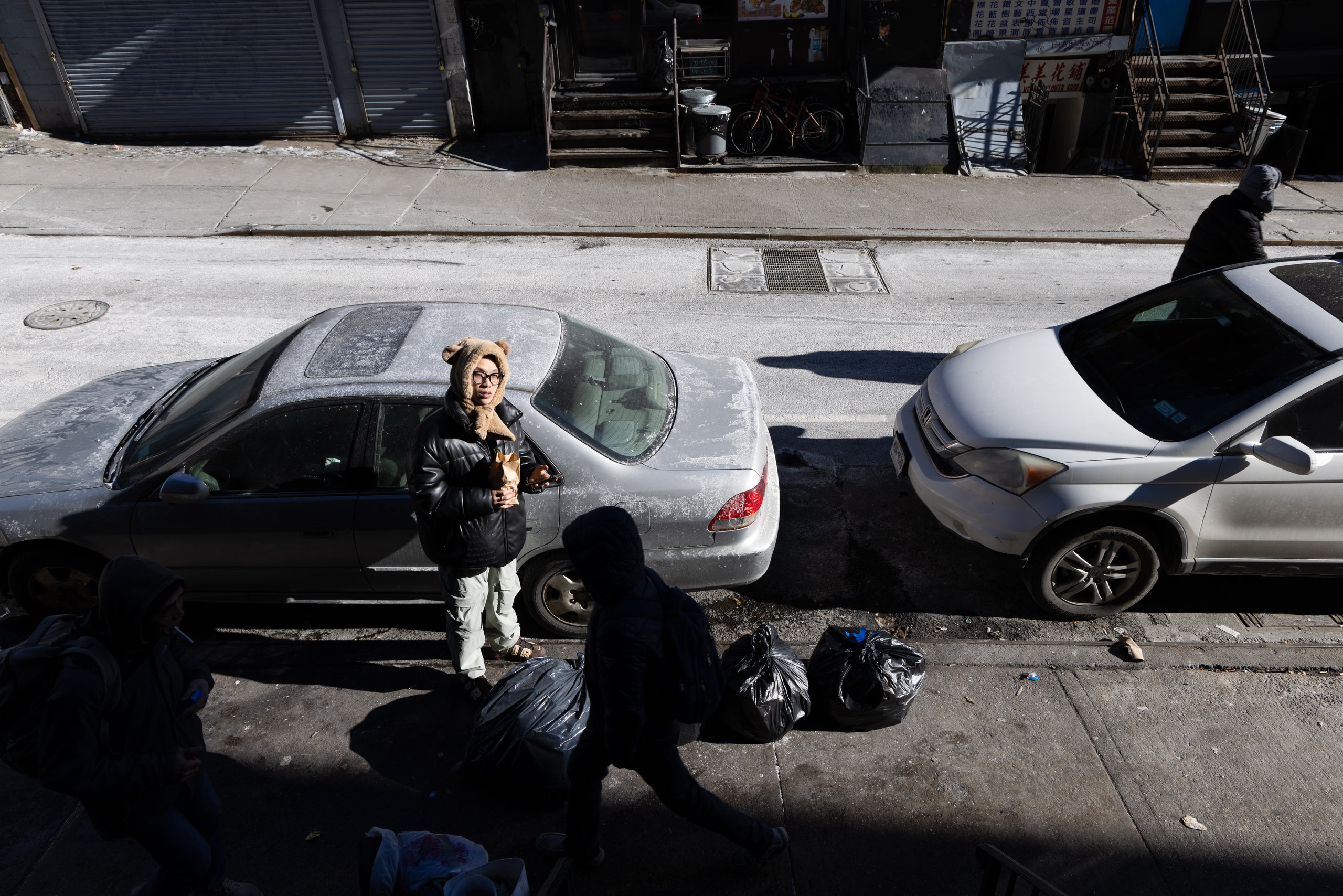 Seen from above, a man with bags between parked cars — Win or Lose