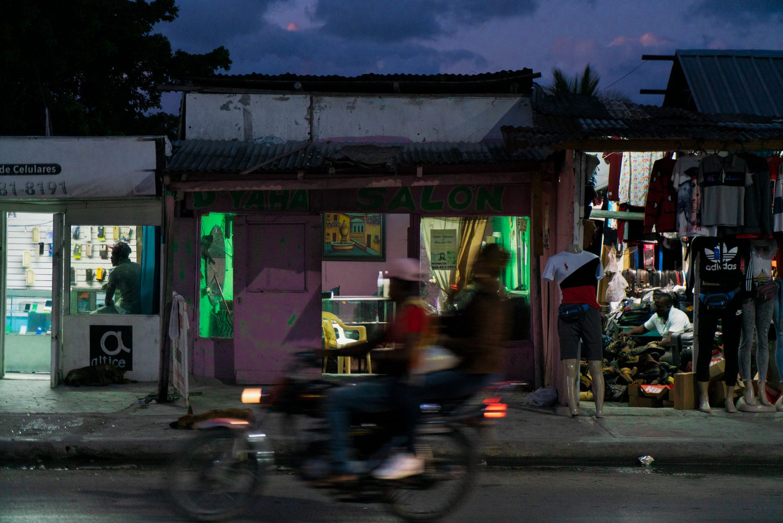 A shopfront at night, a motorcycle parked outside — Punta Cana