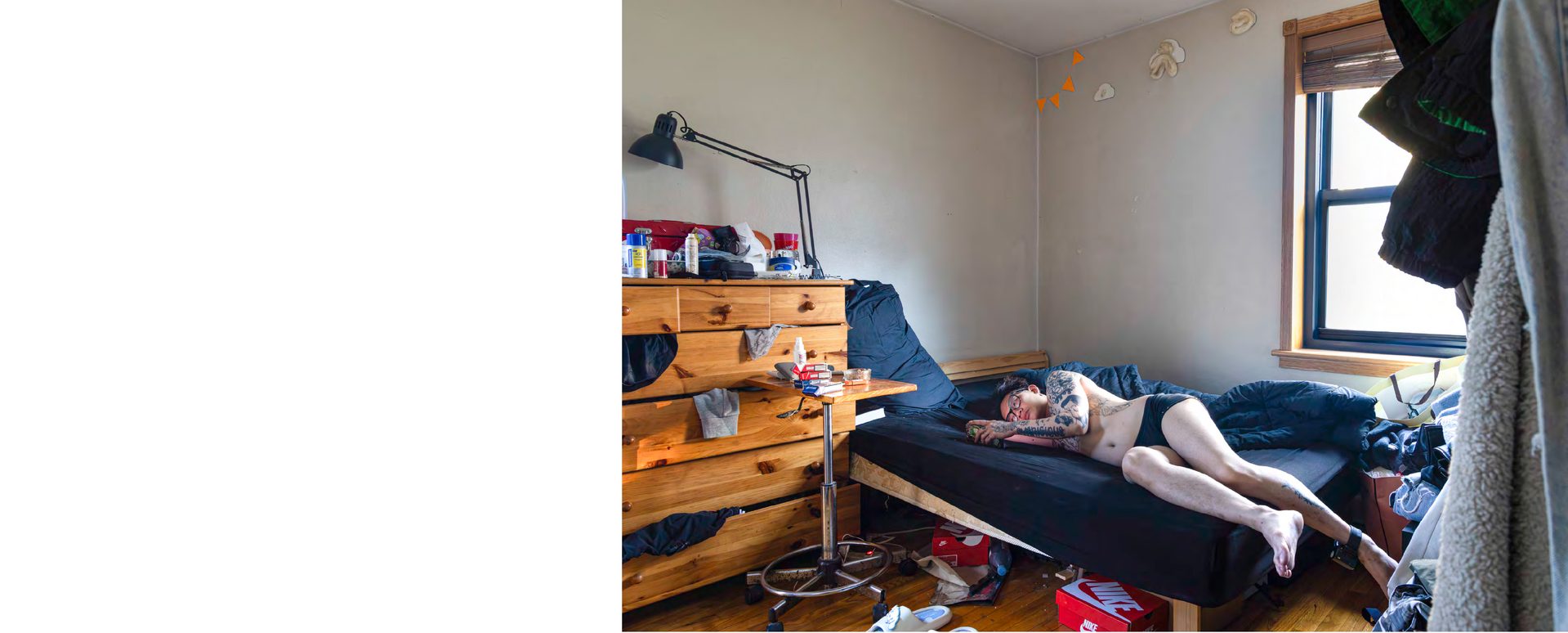 Interior spread from the Win or Lose photobook — a photograph of Win lying on his bed fills the right-hand page