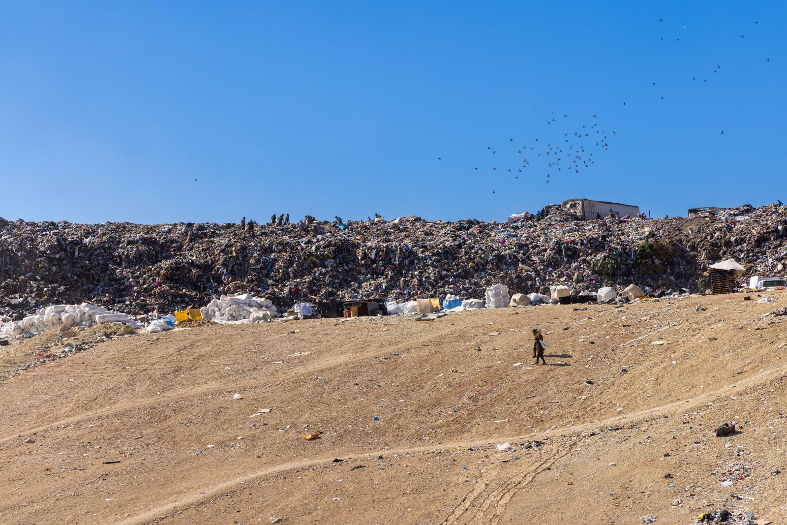 A barren dusty hillside under a clear sky — The Liminal Innocence